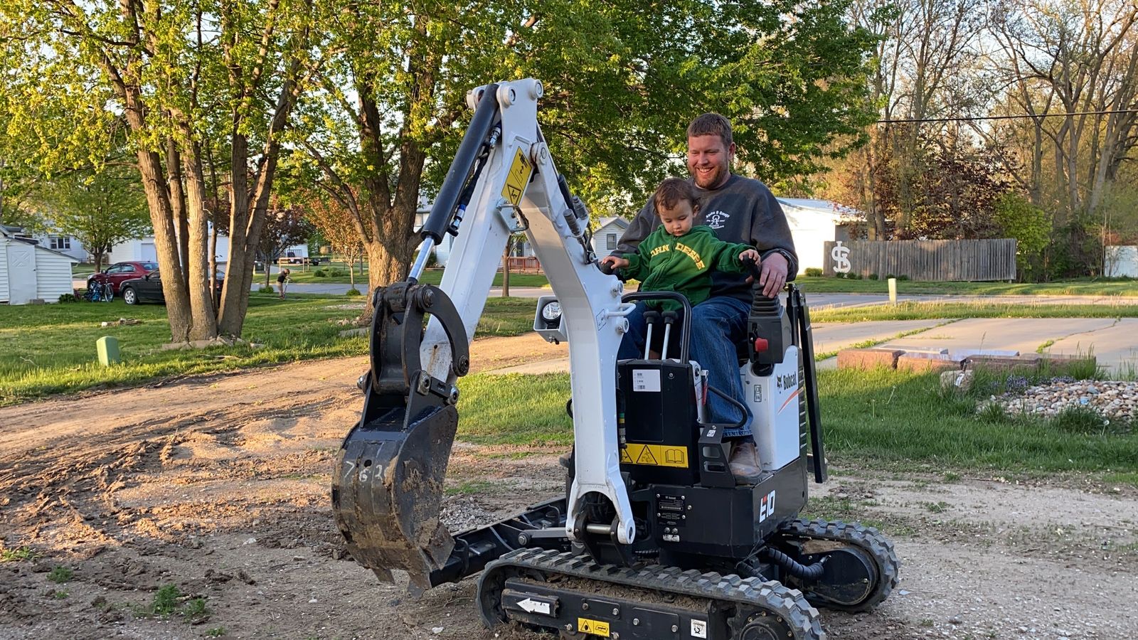 D2 Land & Dirt — a father and son together in the cab of a mini excavator, the next generation learning the trade