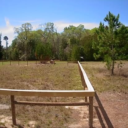 Post and rail fence across open Florida pasture
